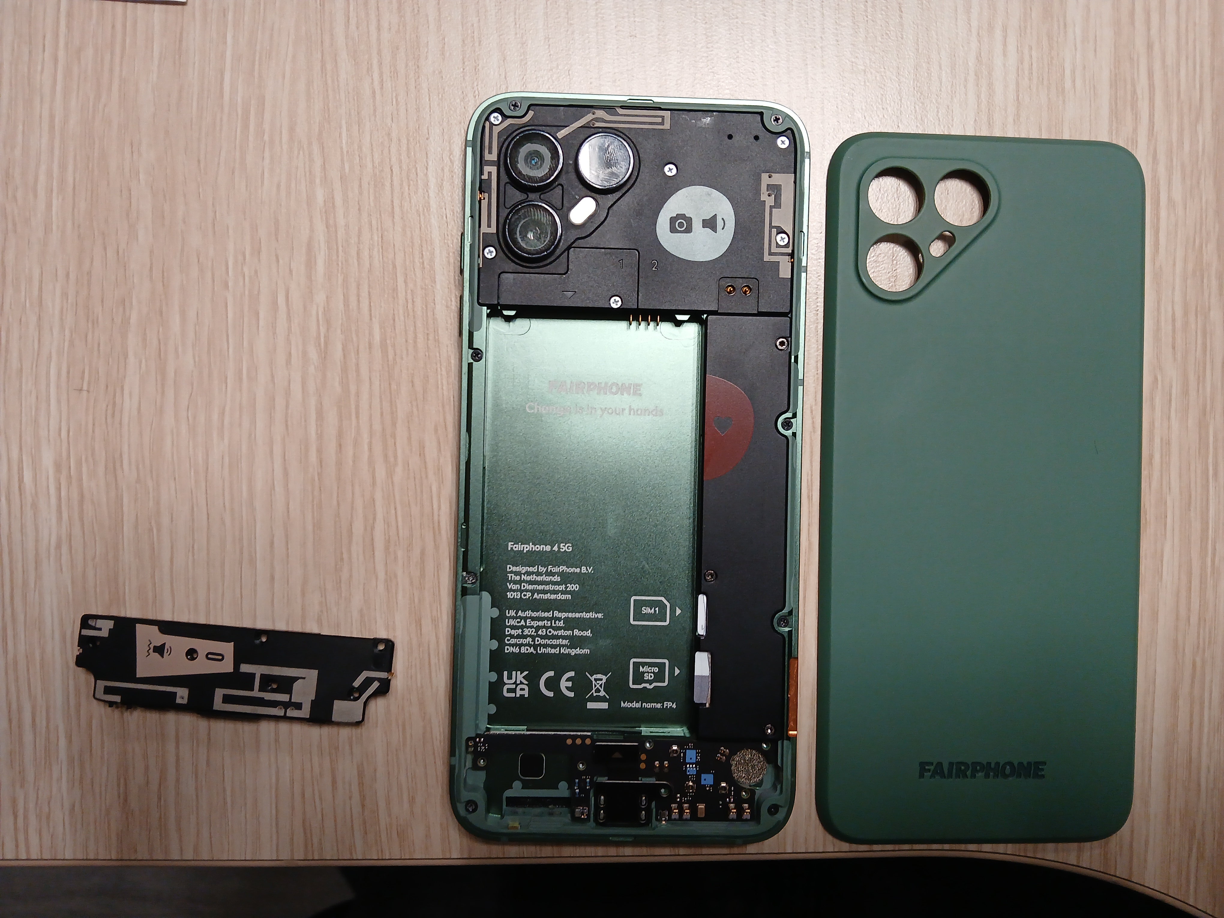 Le Fairphone 4 ouvert, la batterie retirée et le module avec le haut-parleur sorti afin de libérer l’accès au port USB-C.